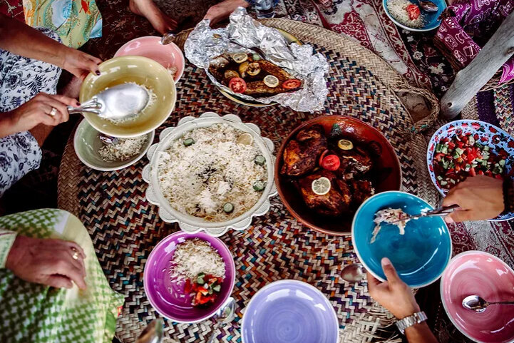 A shared meal arranged on a woven rug
